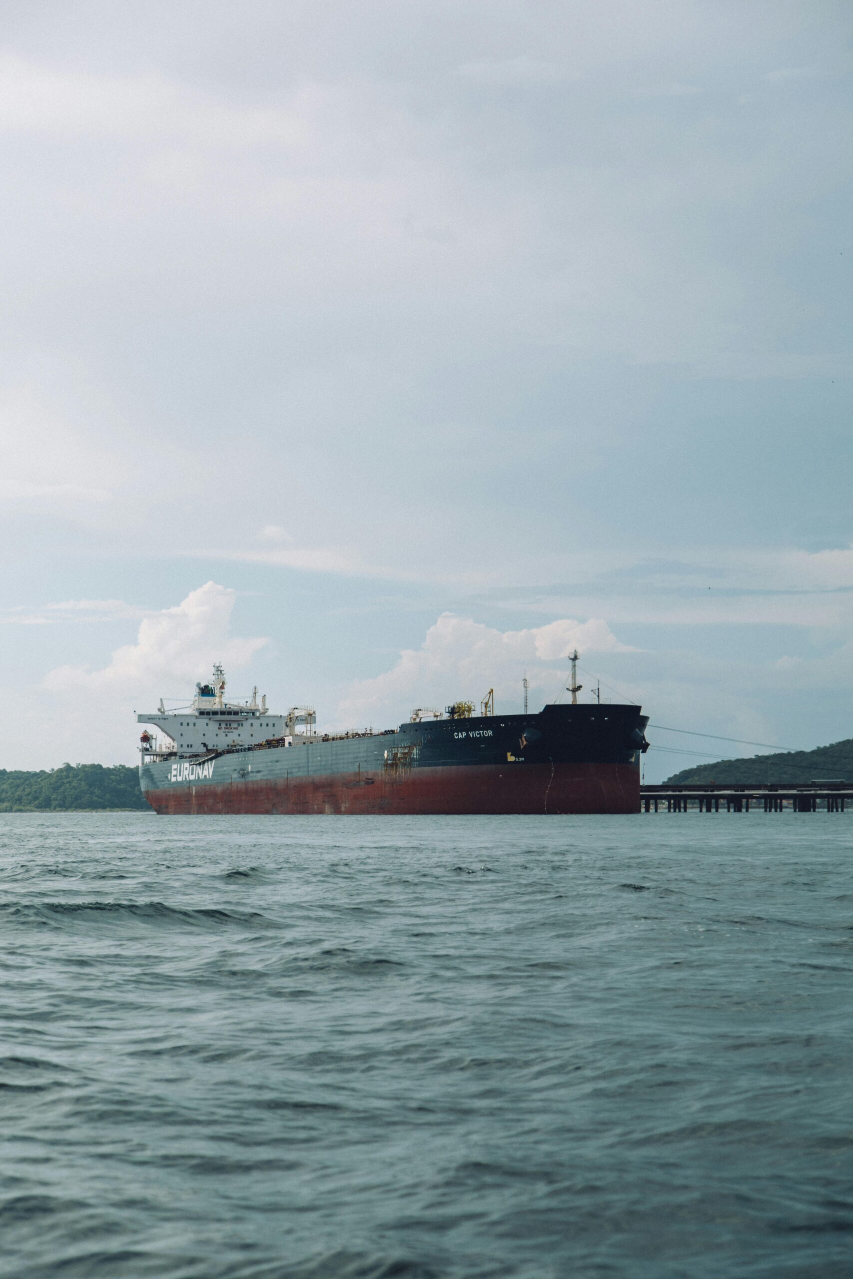 A bulk carrier ship navigates the open sea near Bahia, Brazil under a clear sky.